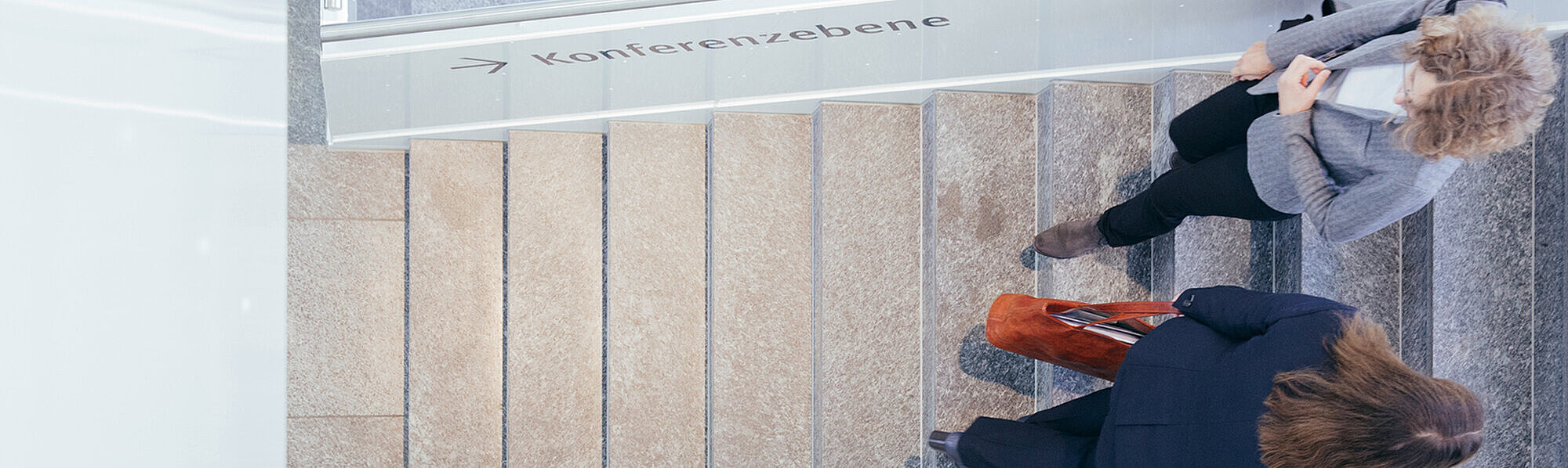 zwei Frauen auf der Treppe in einem Tagungszentrum